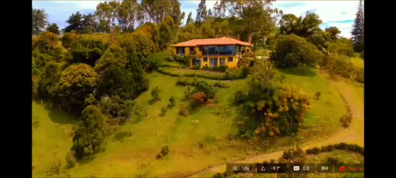 Fotograma del video: vista de la casa desde la zona verde de la finca