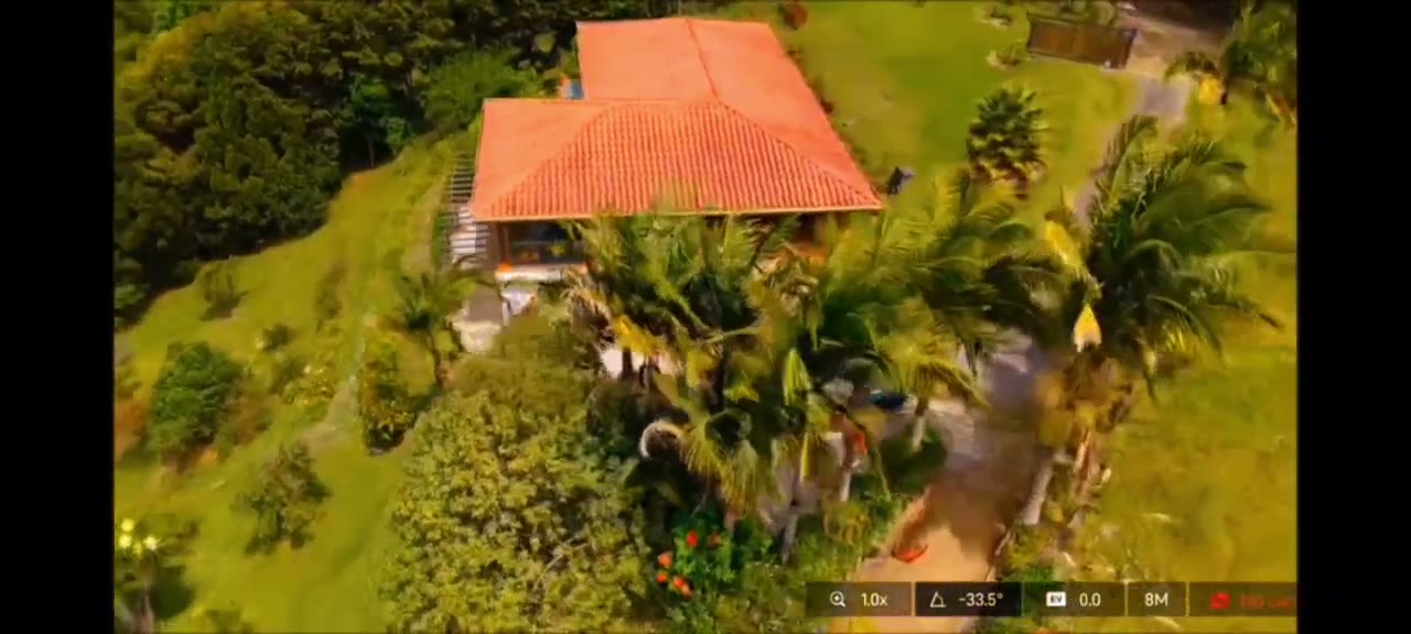 Fotograma del video: vista aérea lateral de la casa y sus jardines